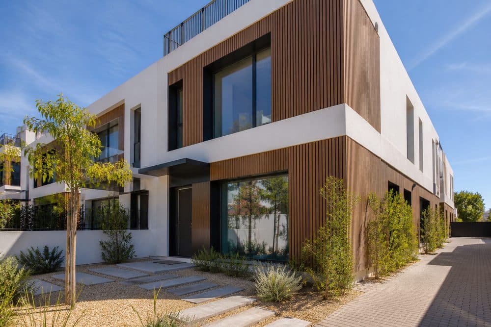 Adosado contemporáneo de hormigón blanco y madera
